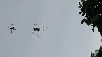 Drone transportando estação de coleta de dados (estacionada sobre a copa das árvores durante a noite)